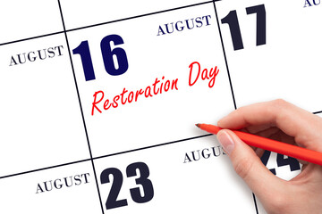 August 16. Hand writing text Restoration Day on calendar date. Save the date.