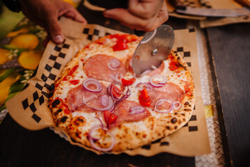 Valmiera, Latvia - August 17, 2024 - Close-up of a fresh pizza topped with salami, onions, and...