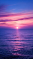 Obraz premium Serene ocean sunset with a pink and purple sky reflecting over calm waters. The soothing colors create a peaceful and tranquil atmosphere.