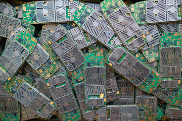 pile of electronic waste on factory floor is circuit board of mobile phone waiting to be processed...