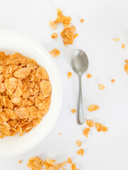 Bowl of Crispy Cornflakes with Spoon on White Background