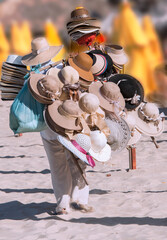 Hat Seller walking in the sand to sell hats for tourists. Futuro Beach. Fortaleza. Ceara, Brazil,...