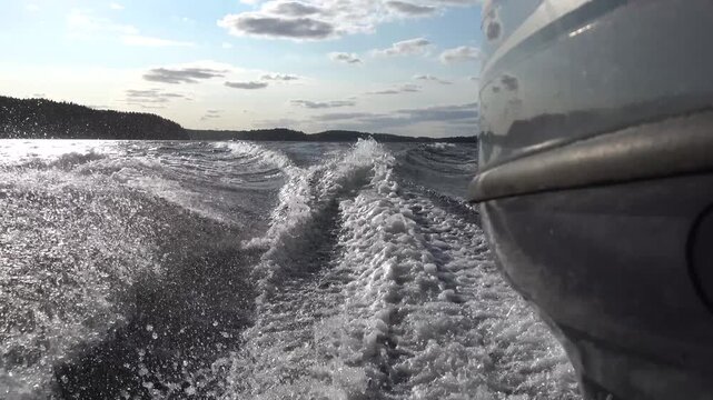 Stockholm, Sweden A closeup of a powerful outboard motor speeding through a lake and its wake.  