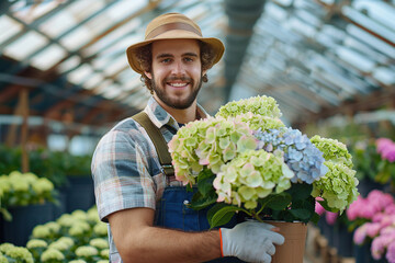 Young man with wooden crate gardening flowers in greenhouse - Powered by Adobe