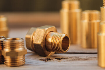 Brass Plumbing Fittings - A brass fitting lying on rustic boards on a sunny day (selective focus)