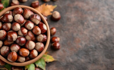 Freshly gathered chestnuts in a rustic bowl on a textured surface with autumn leaves