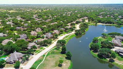 Neighborhood pond park with walking pathway trail in upscale lakeside residential area, two-story...