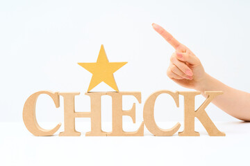 「CHECK」と並べられたアルファベットの木製ブロック