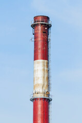 An industrial chimney against a clear sky, painted white and red | Komin przemysłowy na tle czystego nieba, pomalowany na biało-czerwono