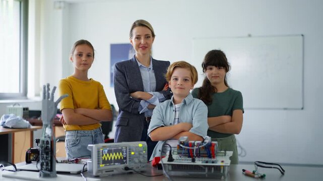 Children learning robotics in Elementary school. Young students building robot in after school robotics club. Field trip to real robotics laboratory.
