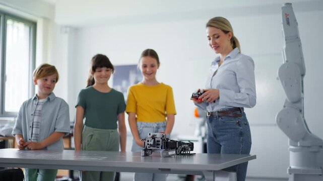 Children learning robotics in Elementary school. Young students building robot in after school robotics club. Field trip to real robotics laboratory.