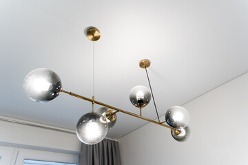An elegant chandelier hangs from the ceiling in the meticulously decorated room, providing warm...