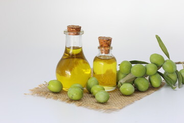 olive oil and green olives on white background