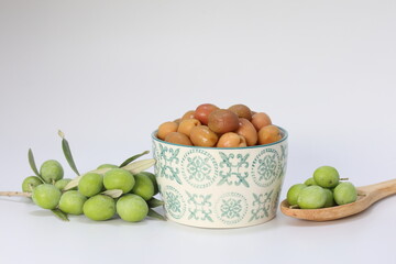 Green and pickled olives on white background
