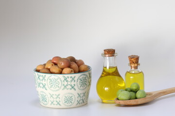 olive oil and pickled green olives on white background