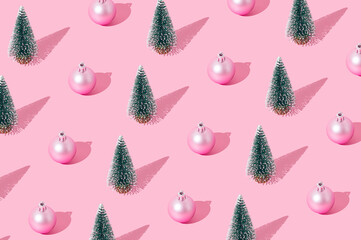Trendy Christmas pattern composition made of green Xmas tree and pink Christmas bauble on pastel pink background. Creative minimal Christmas and New Year concept. Festive holiday pastel backdrop.