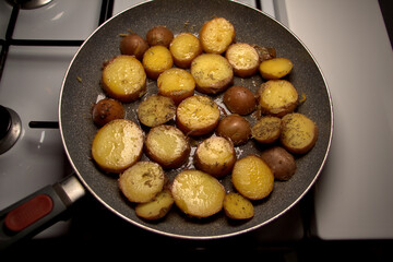 Gekochte Pellkartoffeln mit Rosmarin in der Bratpfanne