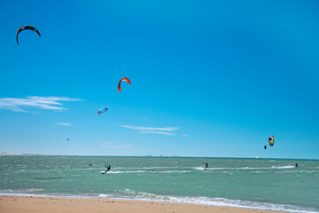 Practice of Kiteboarding or kitesurfing, a sport that involves using wind power with a large power kite to pull a rider across a water, land, snow, sand. Cumbuco Beach, Fortaleza, Ceara, Brazil. 2020