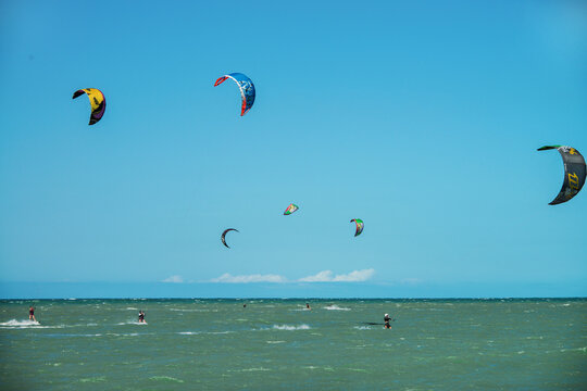 Practice of Kiteboarding or kitesurfing, a sport that involves using wind power with a large power kite to pull a rider across a water, land, snow, sand. Cumbuco Beach, Fortaleza, Ceara, Brazil. 2020