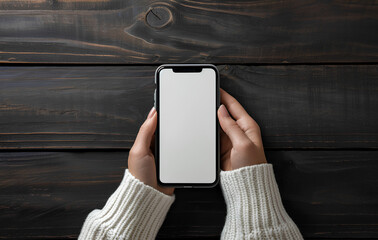 Woman holding an iPhone on a wooden table in the office