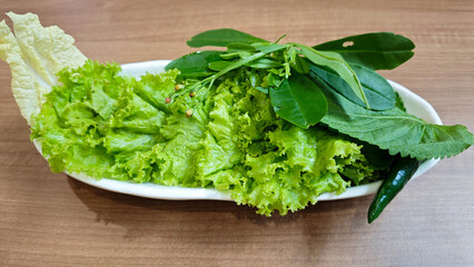 Fresh Green Lettuce and Assorted Vegetables on a Wooden Table in a Restaurant