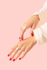 Womans hands with red manicure on pink background. Beauty salon concept
