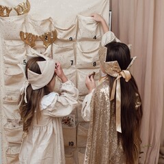 Little happy child opening first day in handmade advent calendar made from toilet paper rolls.