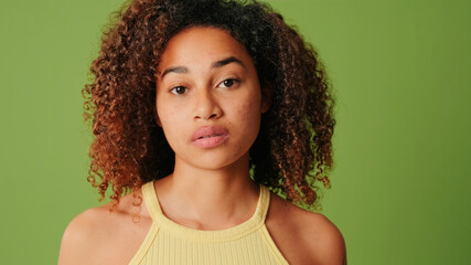 Close-up portrait of African American girl looking to camera on green screen background