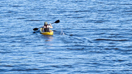 People are enjoying kayak on a river at a sunny summer day