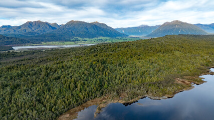 Obraz premium Remote Kapitea Reservoir reflections surrounded by mountain ranges , near Kumara West Coast NZ