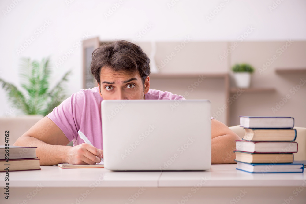 Poster Young male student preparing for exams at home