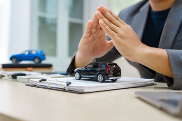 Asian business professional in a formal suit works at a desk, reviewing financial charts. manage car insurance claims, analyze auto loan options, sign lease agreements for vehicle transactions.