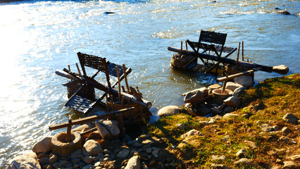 Wood water wheel Baler Machine in Agriculture Farm impeller lifted pumping water in river. Wooden Water Baler Machine green garden Farm blades by windy natural. Sustainable Resources Environment © aFotostock