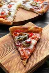 Wooden board with delicious pizza Diablo on table, closeup