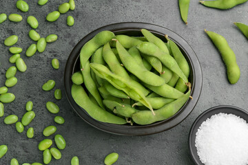 Raw green edamame soybeans and pods on grey table, flat lay