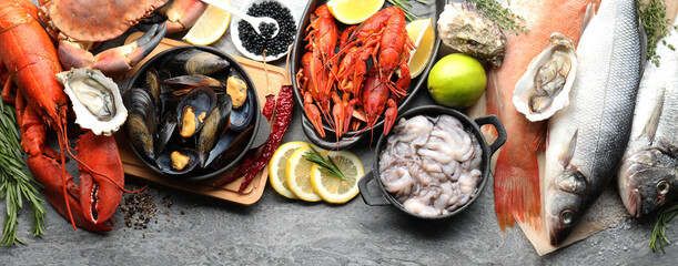 Many different fresh sea food on grey table, flat lay. Banner design