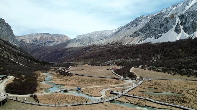 Drone shot of the scenic and breathtaking Yading nature reserve luorong pasture with boardwalk and rest area for tourist to appreciate nature. Located in Garze Tibetan Autonomous Prefecture, Sichuan