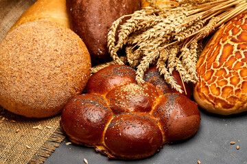 Assortment of freshly baked bread loaves with wheat stalks, tradition and artisanal baking