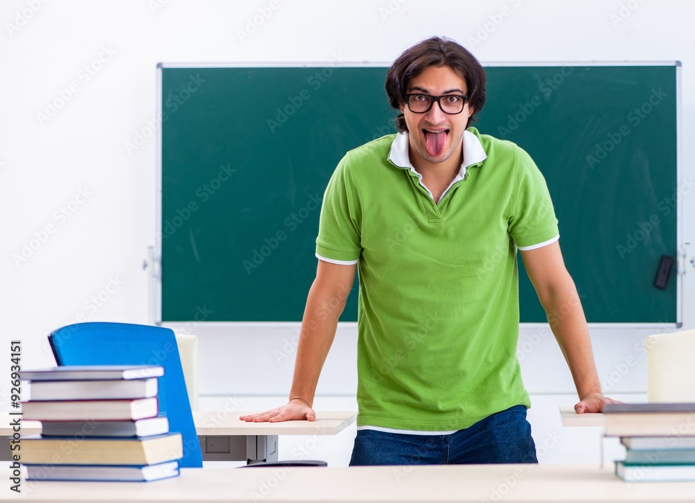 Wall mural young student doing physical exercises in the classroom