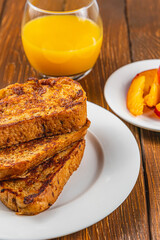 French toast on a plate with blueberries, orange juice, nectarine for breakfast