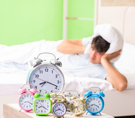 Young man having trouble waking up in early morning