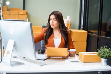 A young Asian businesswoman sits at her table, watching the computer screen.She analyzes, plans,...
