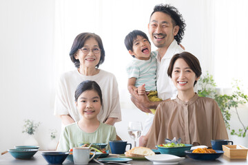 3世代(二世帯住宅)など家族の食卓　カメラ目線で笑顔　父、母、祖母、娘、息子５人のクローズアップ