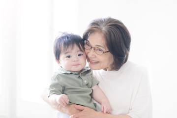 孫を抱くシニア女性　頬ずりをする