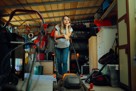 Sad Woman in a Messy Storage Unit Thinking of Decluttering. Stressed person feeling overwhelmed with broke lawn mower
- Powered by Adobe