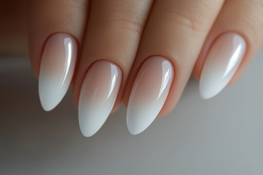  hand with long, painted nails. The nails are painted in a gradient of pink and white
