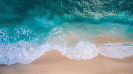 Obraz premium Beautiful top view of turquoise water and sandy beach with waves in aerial drone perspective