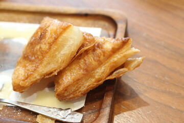 Crispy bread with sweetened condensed milk on table in coffee shop.