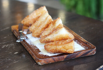 Crispy bread with sweetened condensed milk on table in coffee shop.