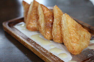 Crispy bread with sweetened condensed milk on table in coffee shop.